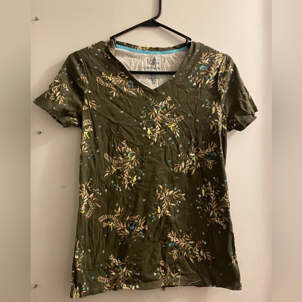 Short sleeved t-shirt with bird print scattered on it.